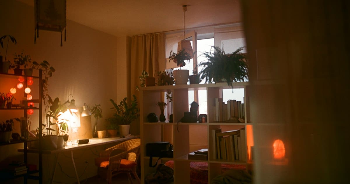 Habitación en penumbra con un escritorio y estanterías
